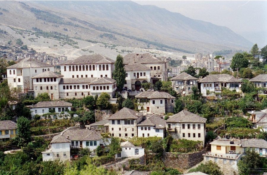 Visit a picturesque village with many houses perched atop a stunning mountain in Albania.